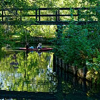 Paddler und Brücke über ein Fließ