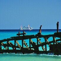 Segelbootwrack mit Kreuzfahrtschiff uSurfern